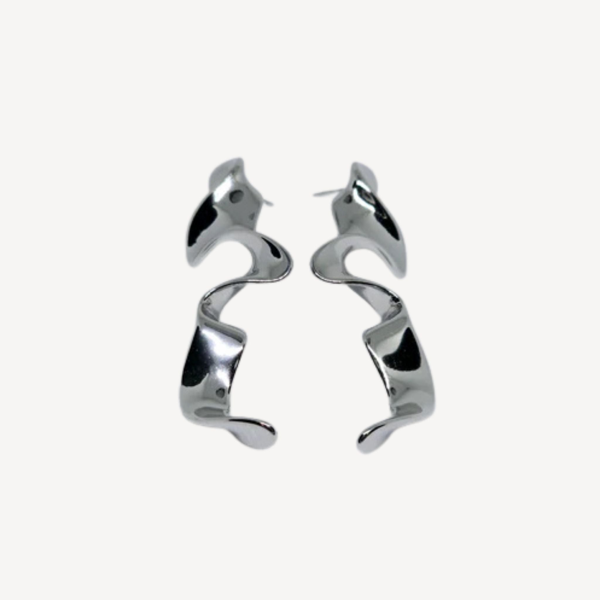 Boucles d’oreilles argentées sculpturales au design ondulé moderne.
