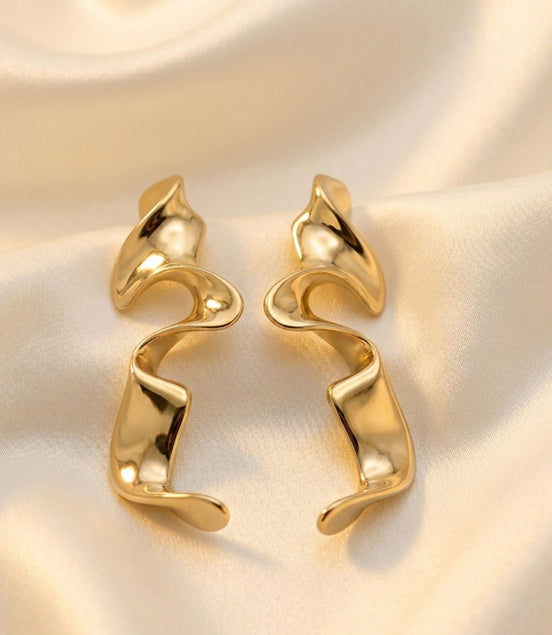 Boucles d’oreilles argentées sculpturales au design ondulé moderne.