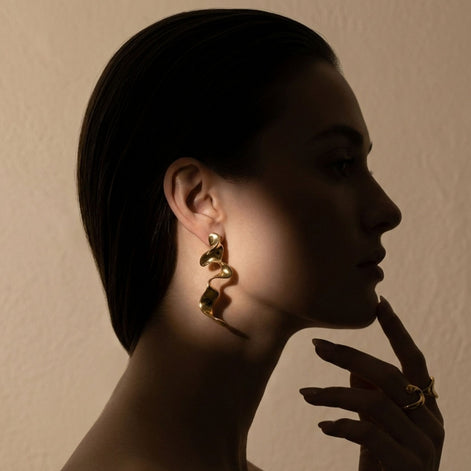 Boucles d’oreilles argentées sculpturales au design ondulé moderne.