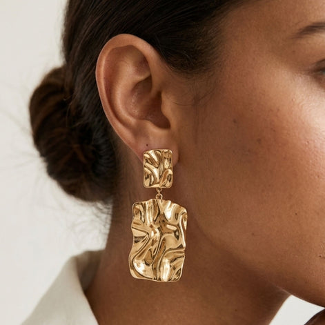 Boucles d’oreilles dorées texturées effet martelé pendantes.