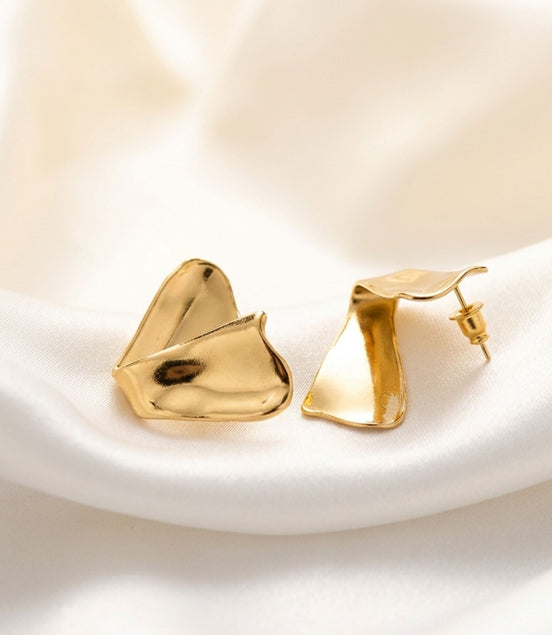 Boucles d’oreilles dorées sculpturales finition brillante.