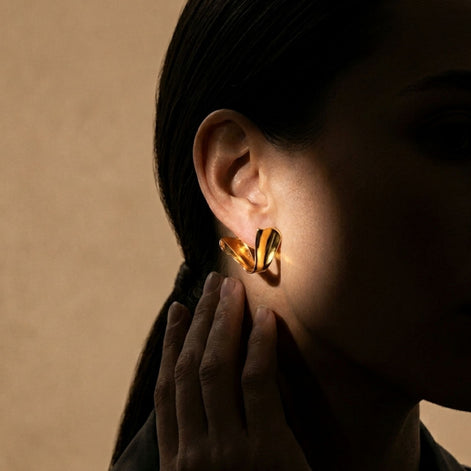 Boucles d’oreilles dorées sculpturales finition brillante.