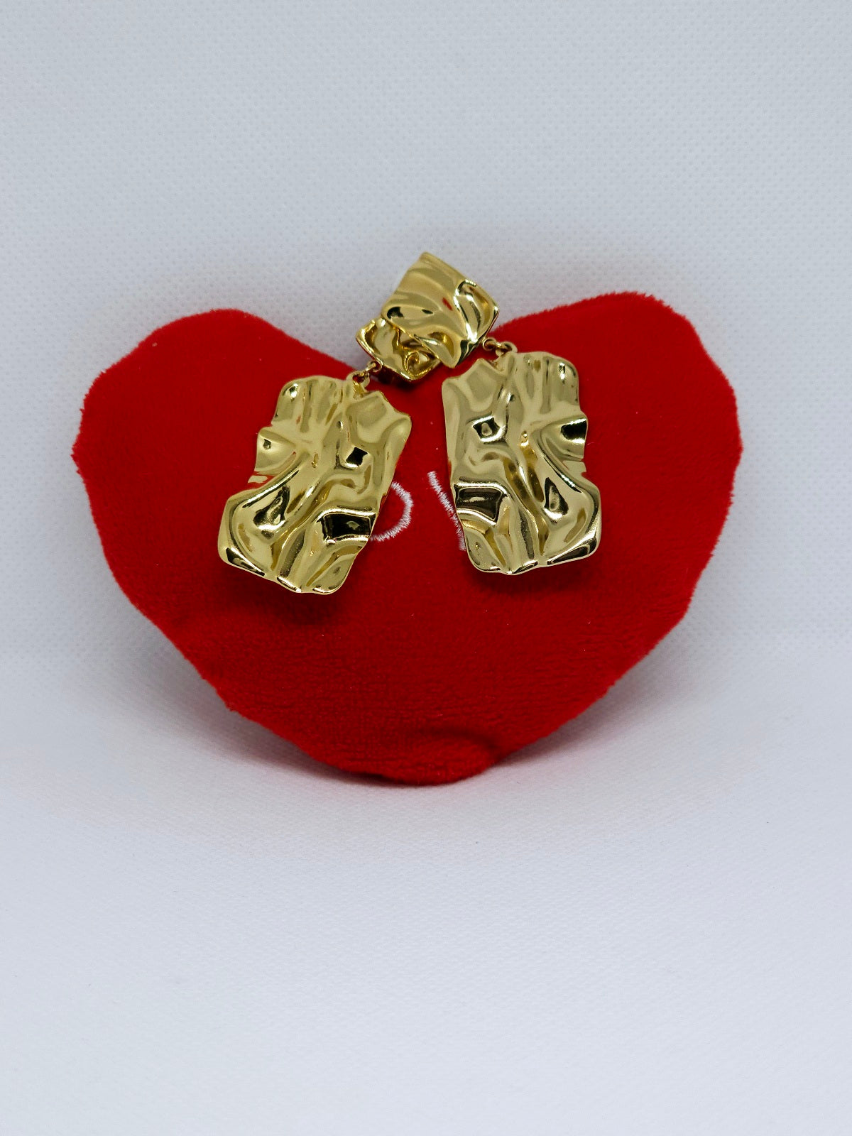 Boucles d’oreilles dorées texturées effet martelé pendantes.