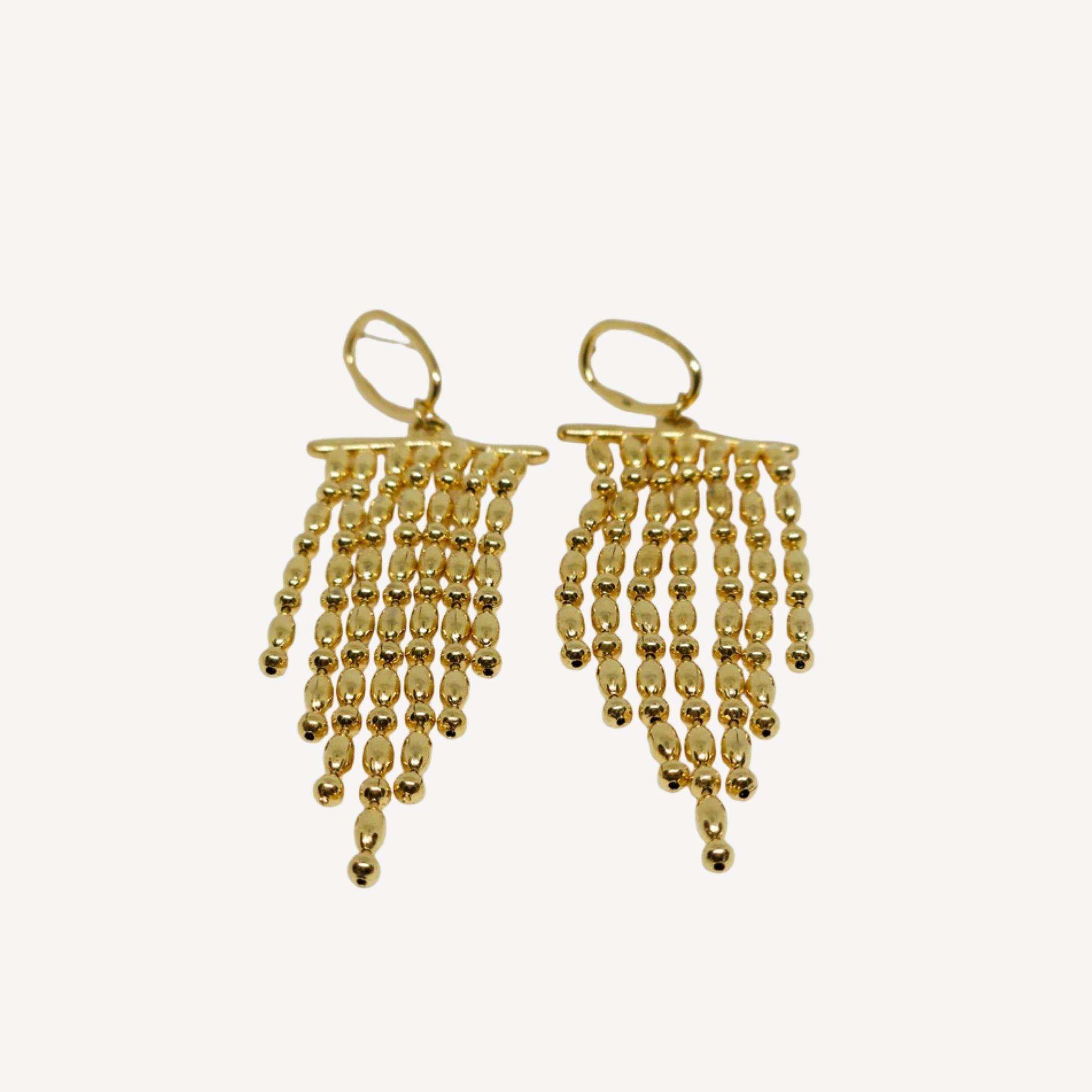 Boucles d’oreilles dorées longues à perles en cascade.