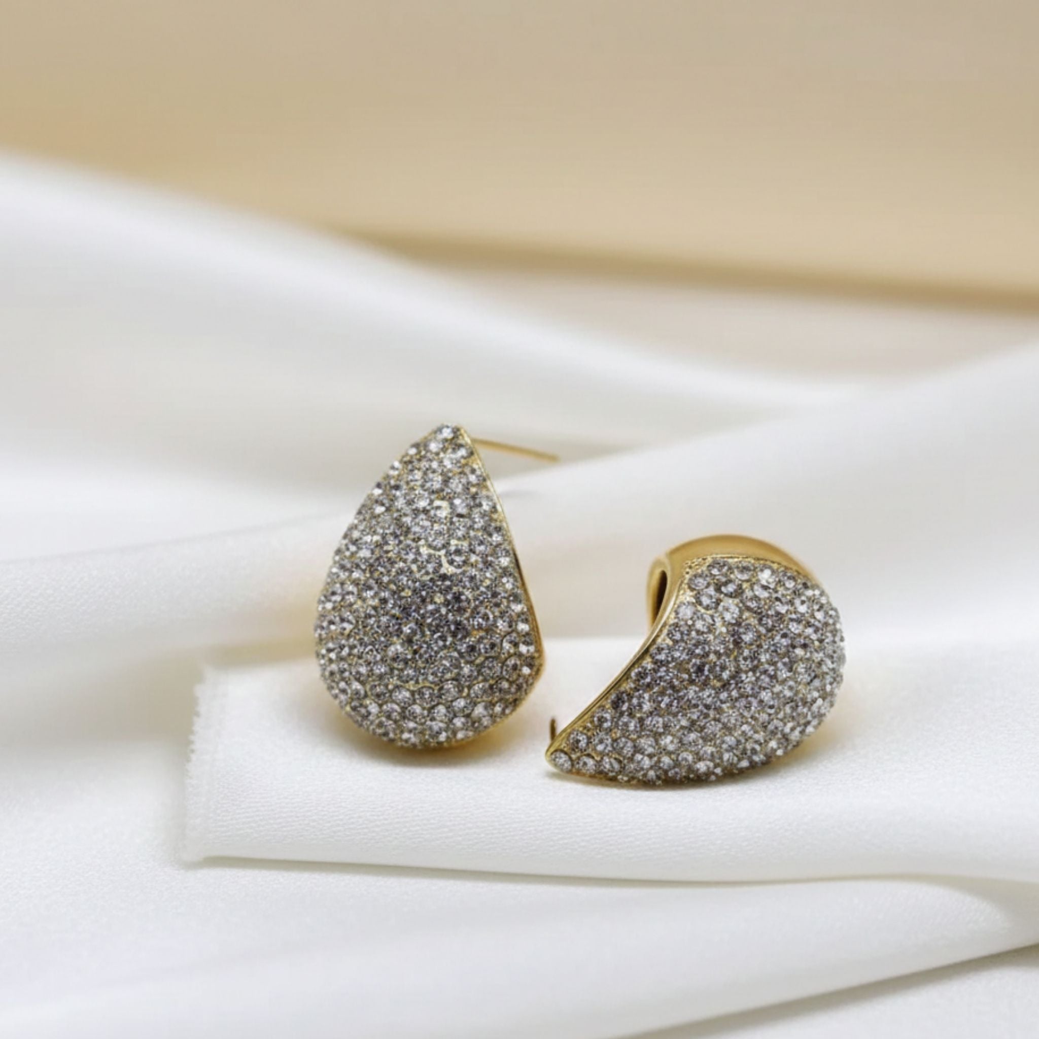 Boucles d’oreilles dorées demi-lune avec cristaux scintillants.