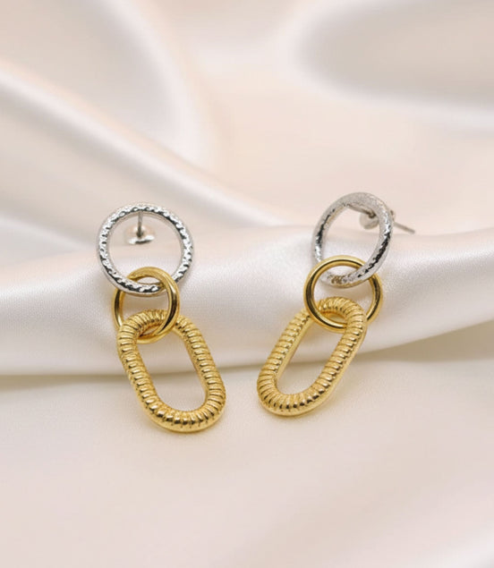 Boucles d’oreilles pendantes bicolores avec maillons dorés texturés.