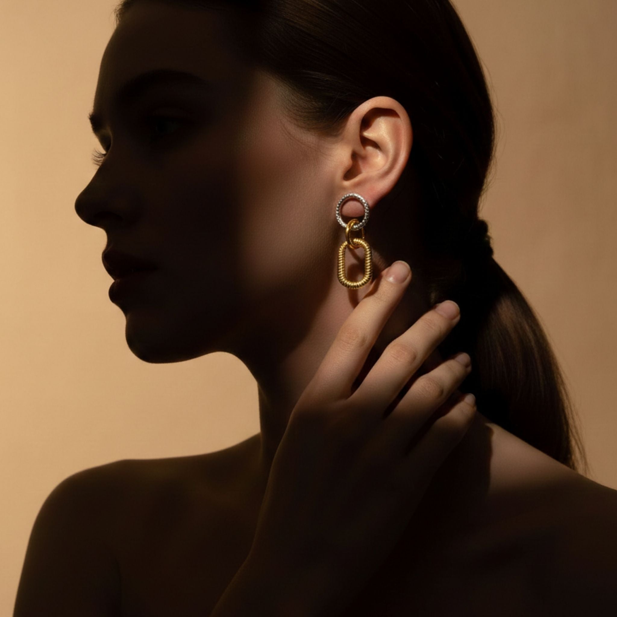 Boucles d’oreilles pendantes bicolores avec maillons dorés texturés.
