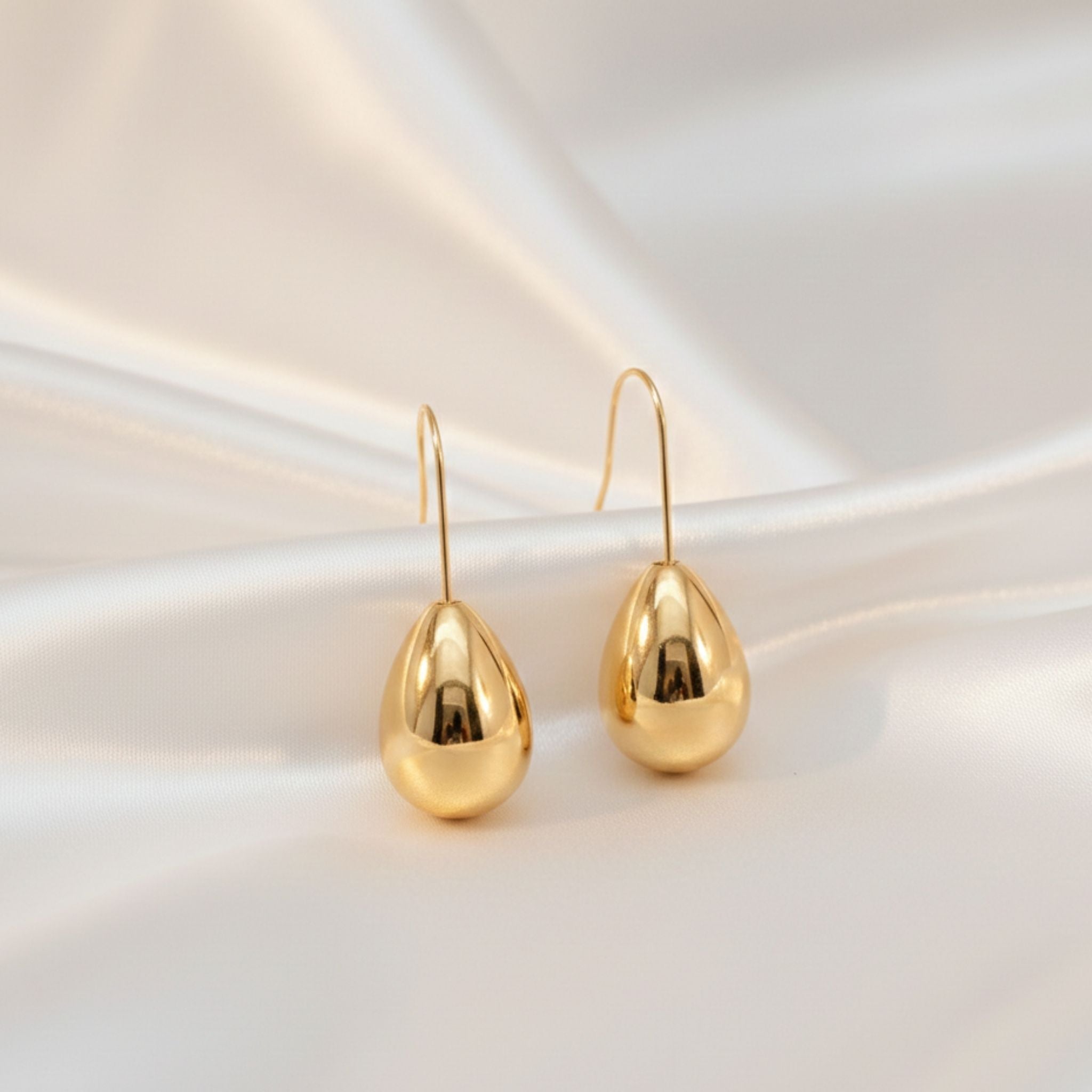 Boucles d’oreilles argentées en forme de goutte brillante.