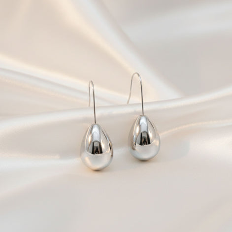 Boucles d’oreilles argentées en forme de goutte brillante.