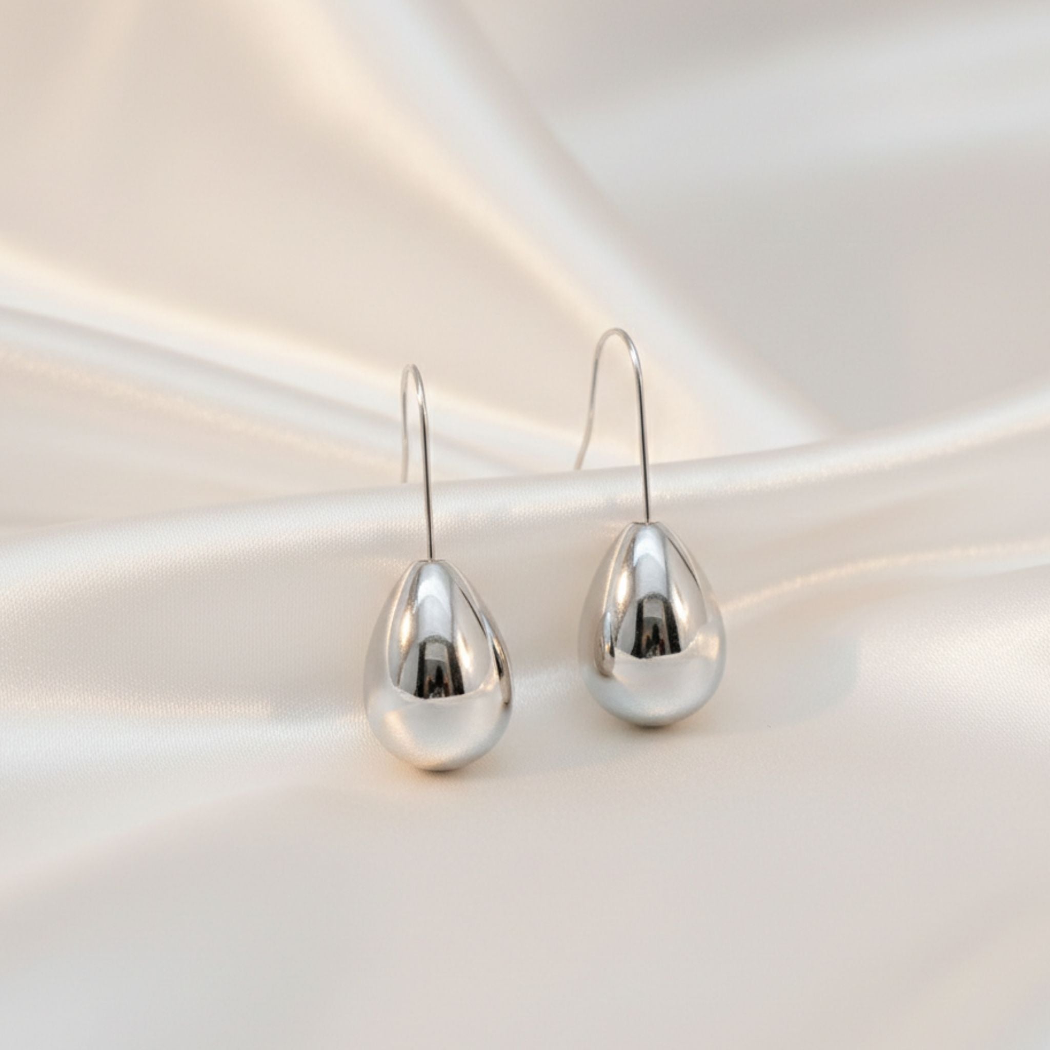 Boucles d’oreilles argentées en forme de goutte brillante.