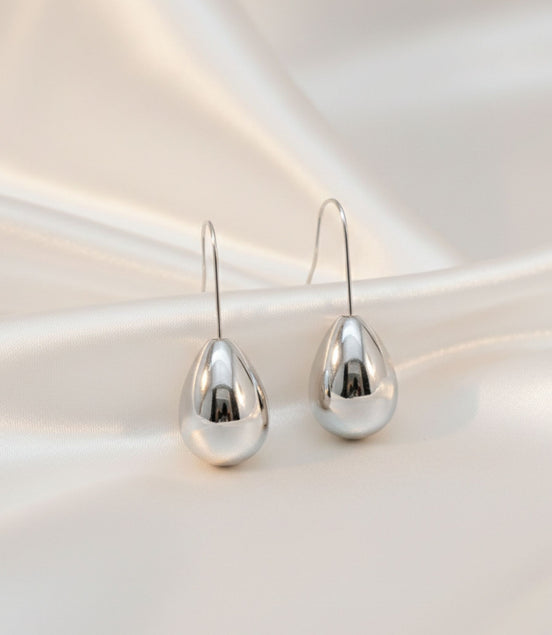 Boucles d’oreilles argentées en forme de goutte brillante.