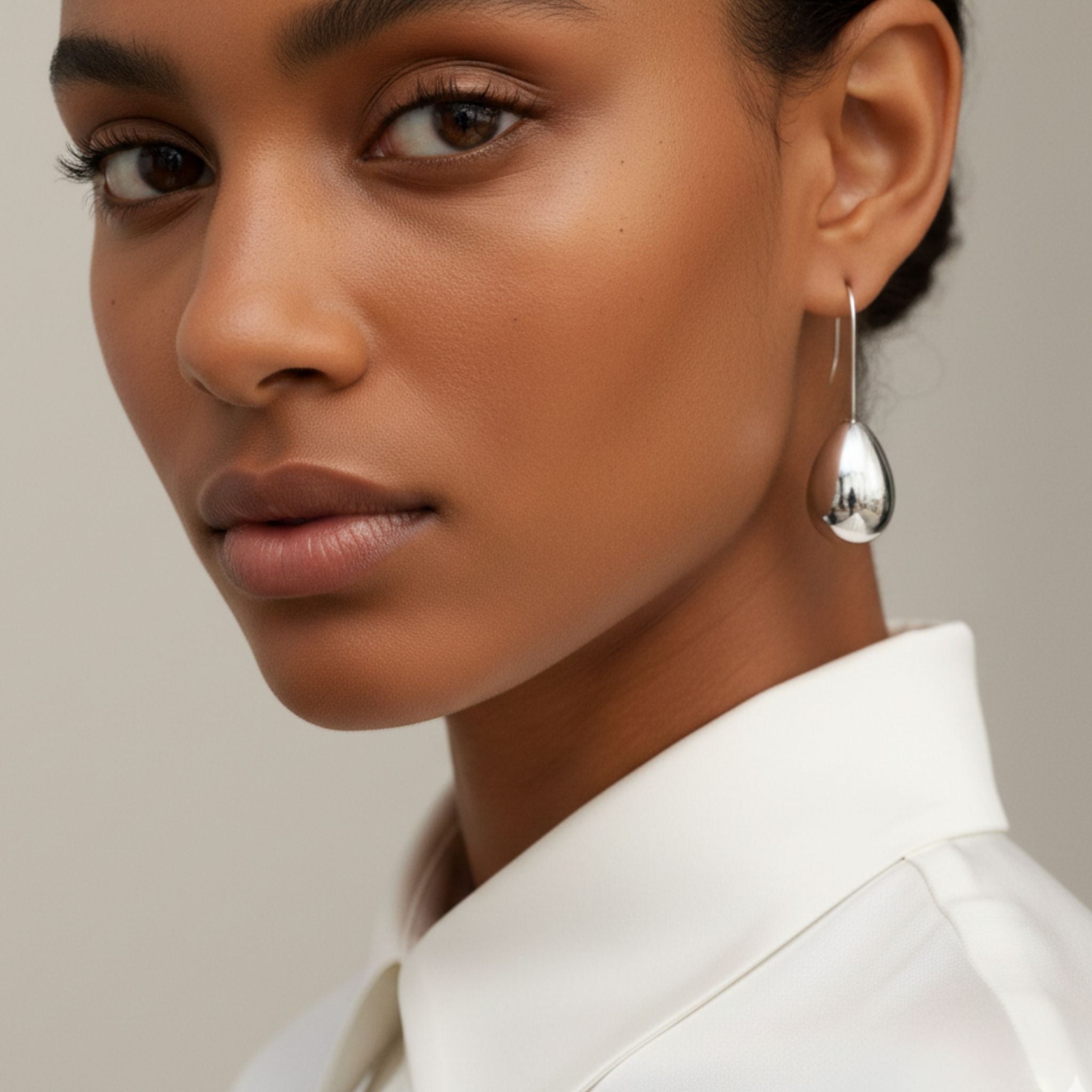 Boucles d’oreilles argentées en forme de goutte brillante.