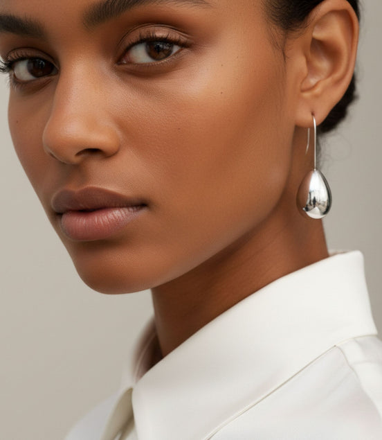 Boucles d’oreilles argentées en forme de goutte brillante.