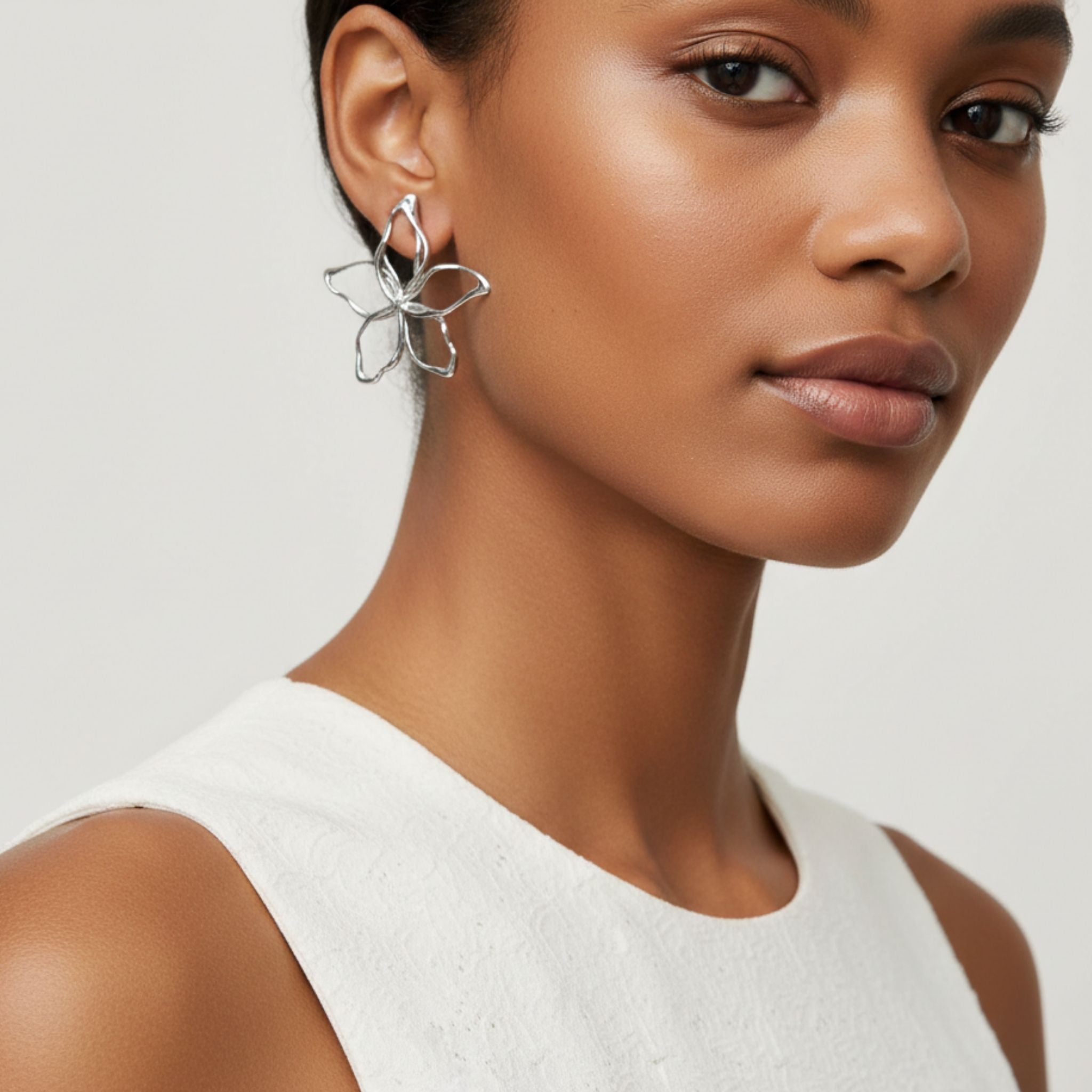 Boucles d’oreilles fleurs argentées ajourées effet miroir.