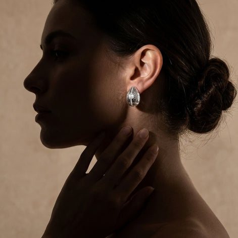 Boucles d’oreilles argentées ovales avec ligne pavée scintillante.