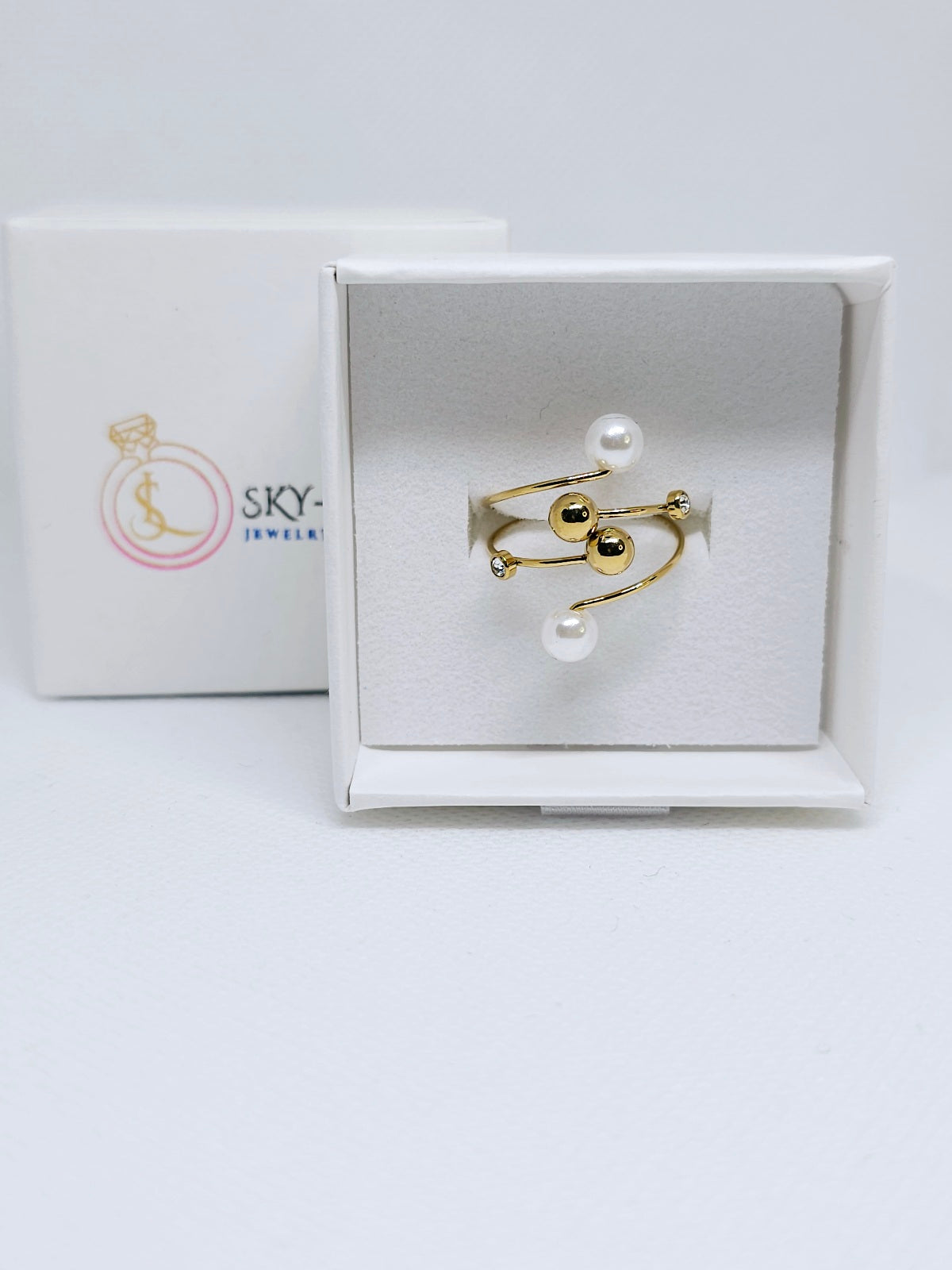 Bague dorée élégante avec perles blanches et strass dans