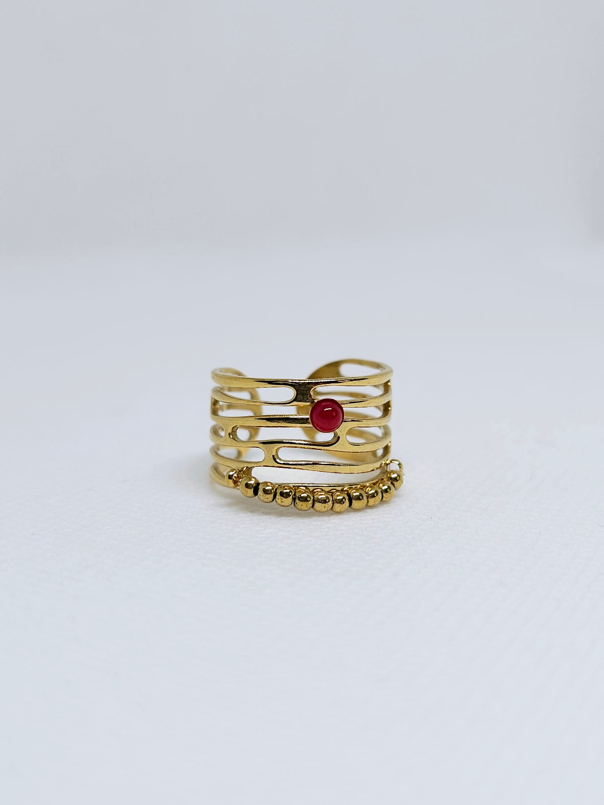 Bague dorée ajourée avec perle rouge