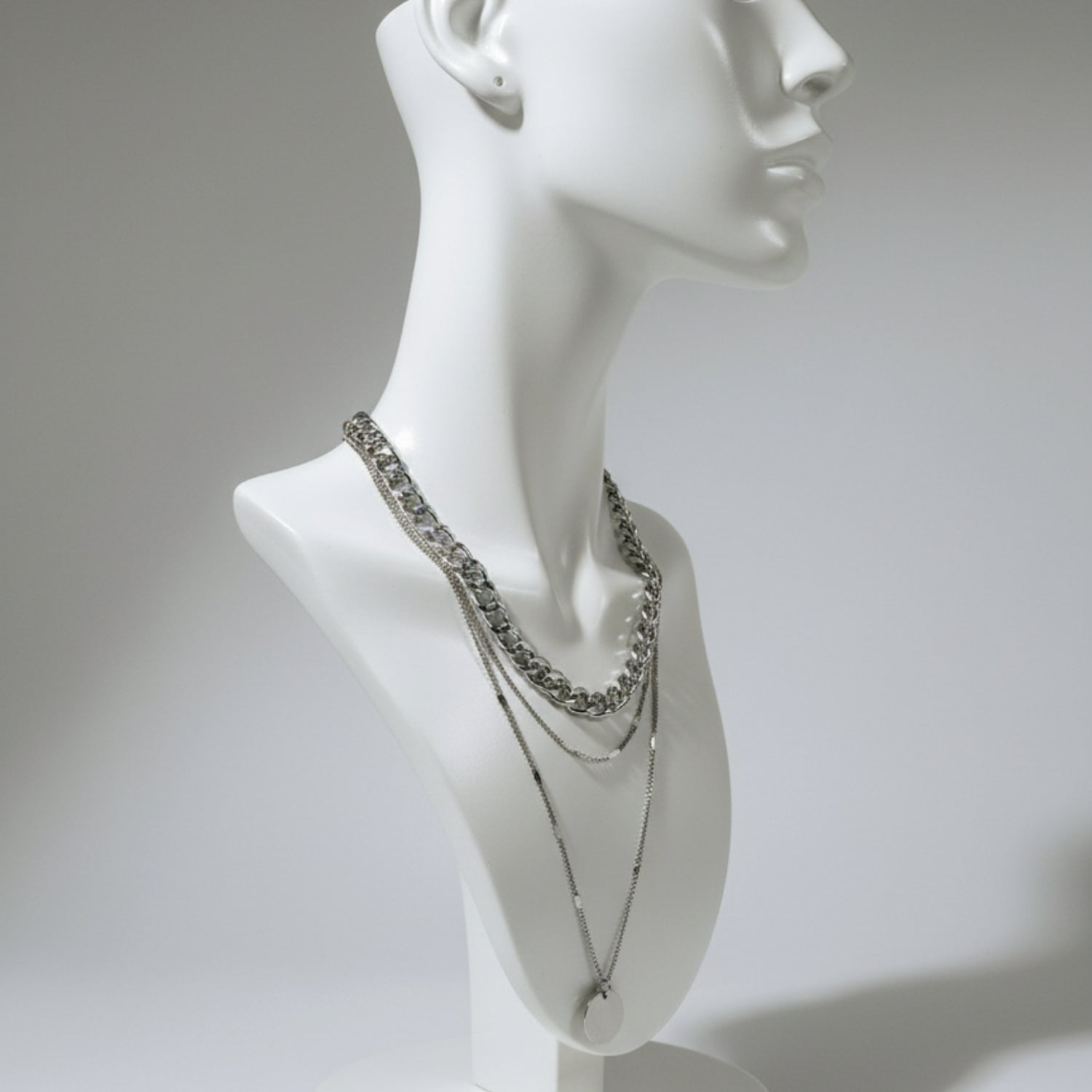 Chaînes fines et médaillon argent posés sur buste